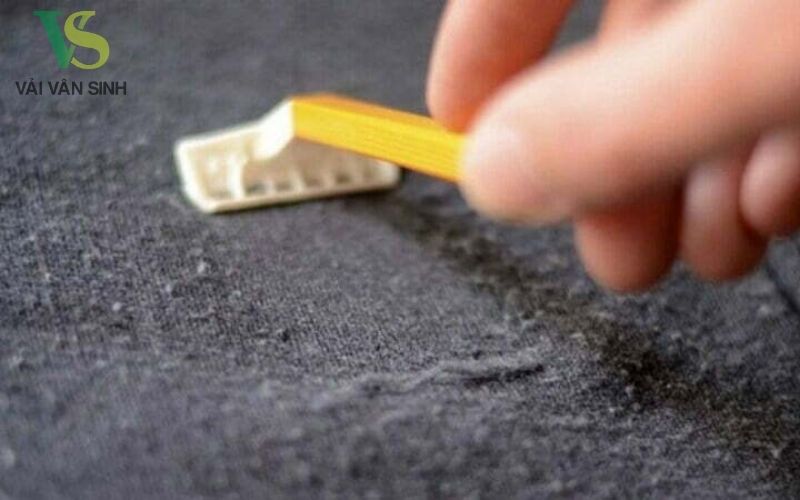 Cách làm sạch bụi vải bám trên quần áo đen bằng dao cạo
